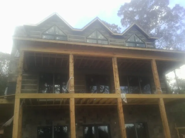 Dormers and porch framing on a large log home under construction — Roof Coating work by our crew in Yountville