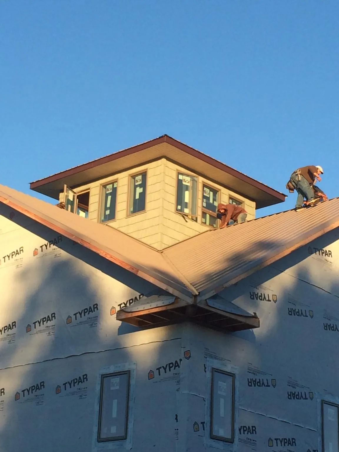 Roofers working around a rooftop cupola on a new metal roof at sunset — Roof Waterproofing in Yountville by Roofing Brothers